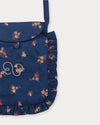 Early Sunday, Miss Sunday Sling in Ditsy Bouquet Navy Blue, made from Printed Cotton Satin fabric, featuring a frill detailed sling purse with flap closure, shown in a closeup flat-lay view