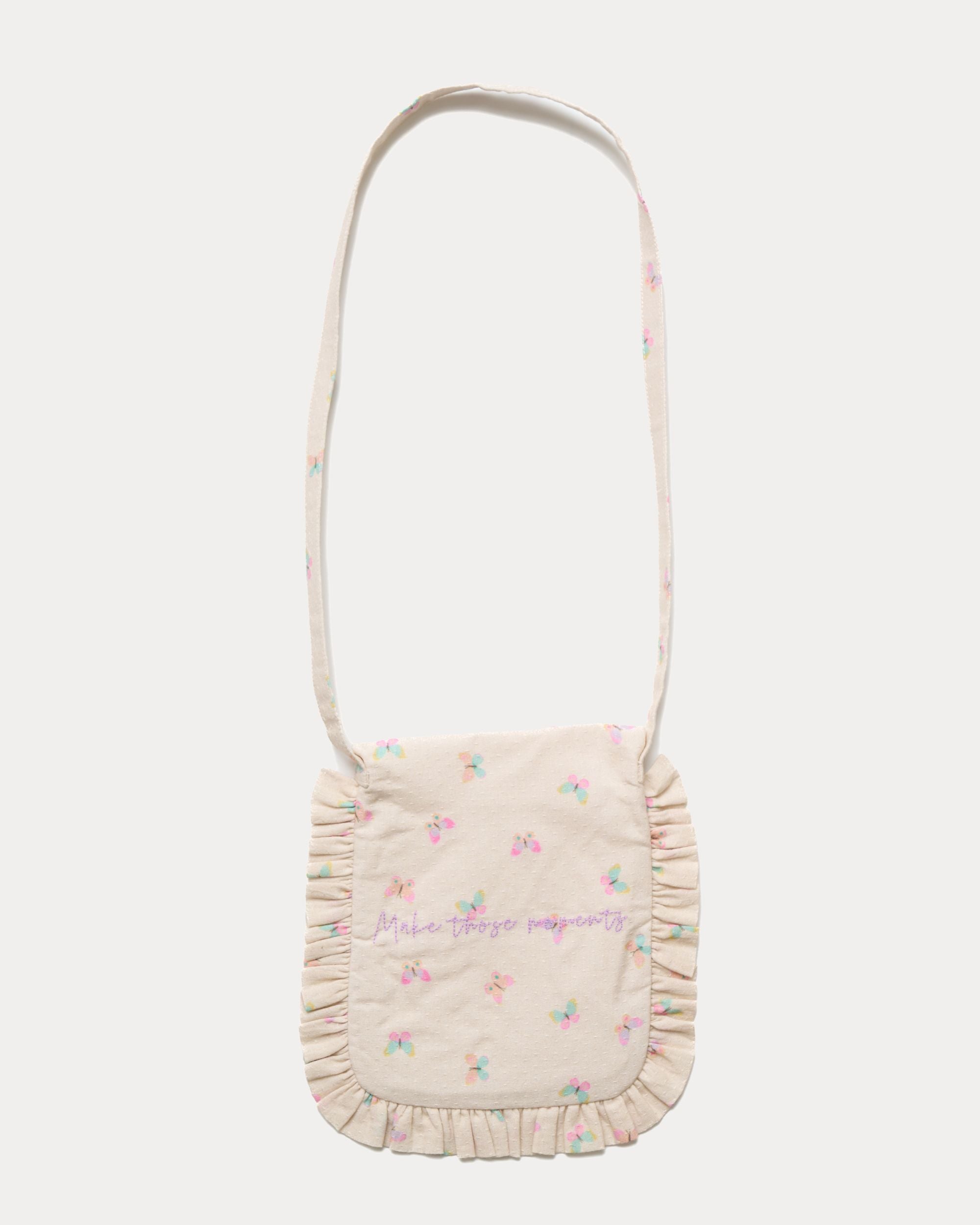 Early Sunday, Miss Sunday Sling in Butterflies print, made from Printed Cotton Tiny Swiss Dobby fabric, featuring a frill detailed sling purse with flap closure, shown in a back flat-lay view