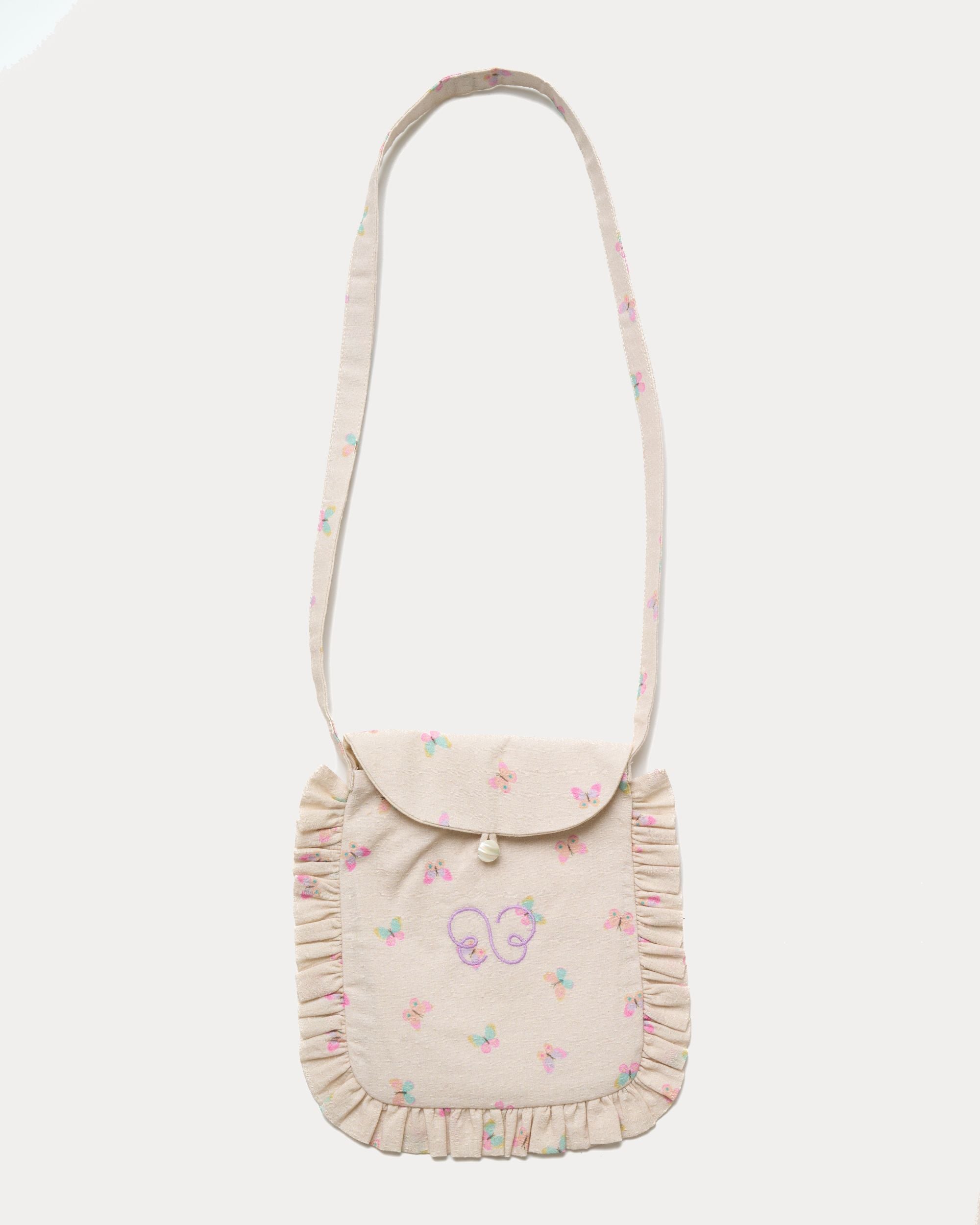 Early Sunday, Miss Sunday Sling in Butterflies print, made from Printed Cotton Tiny Swiss Dobby fabric, featuring a frill detailed sling purse with flap closure, shown in a front flat-lay view