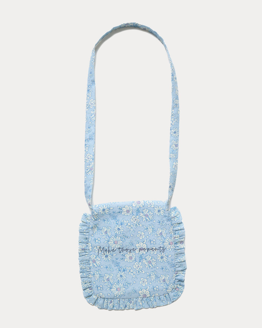 Early Sunday, Miss Sunday Sling in Tonal Floral Blue color, made from Printed Cotton Tiny Swiss Dobby fabric, featuring a frill detailed sling purse with flap closure, shown in back flat-lay view
