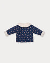 Early Sunday, Molly Baby Quilted Jacket in Ditsy Bouquet Navy, made from Printed Cotton Satin fabric, featuring a sherpa collar & cuffed sleeves, shown in a back flat-lay view