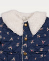Early Sunday, Molly Baby Quilted Jacket in Ditsy Bouquet Navy, made from Printed Cotton Satin fabric, featuring a sherpa collar & cuffed sleeves with snap button closure, shown in a closeup flat-lay view