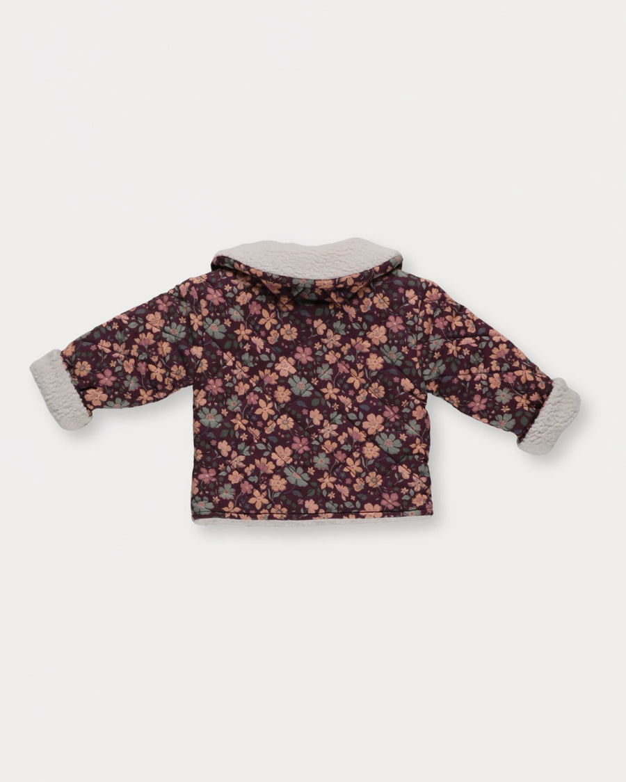 Early Sunday, Molly Baby Quilted Jacket in Garden Flowers Plum, made from Printed Cotton Satin fabric, featuring a sherpa collar & cuffed sleeves, shown in a back flat-lay view