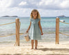 Early Sunday, Natasha Dress in Sea Dream color, made from All-Over Eyelet Embroidered Cotton Schifflie fabric, featuring flattering fit with delicate finishes, combining style and functionality for an effortlessly elegant look, shown in a outdoor shot of model wearing 