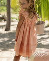 Early Sunday, Natasha Dress in Strawberry color, made from All-Over Eyelet Embroidered Cotton Schifflie fabric, featuring flattering fit with delicate finishes, combining style and functionality for an effortlessly elegant look, shown in a back view of model wearing it