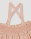 Early Sunday, Olivia Blouse in Pink Sand color, made from Canvas 70% Cotton 30% Linen fabric, featuring smocked bodice for a flexible fit, cross-back strap sand a flared hem, shown in a close-up flat lay view
