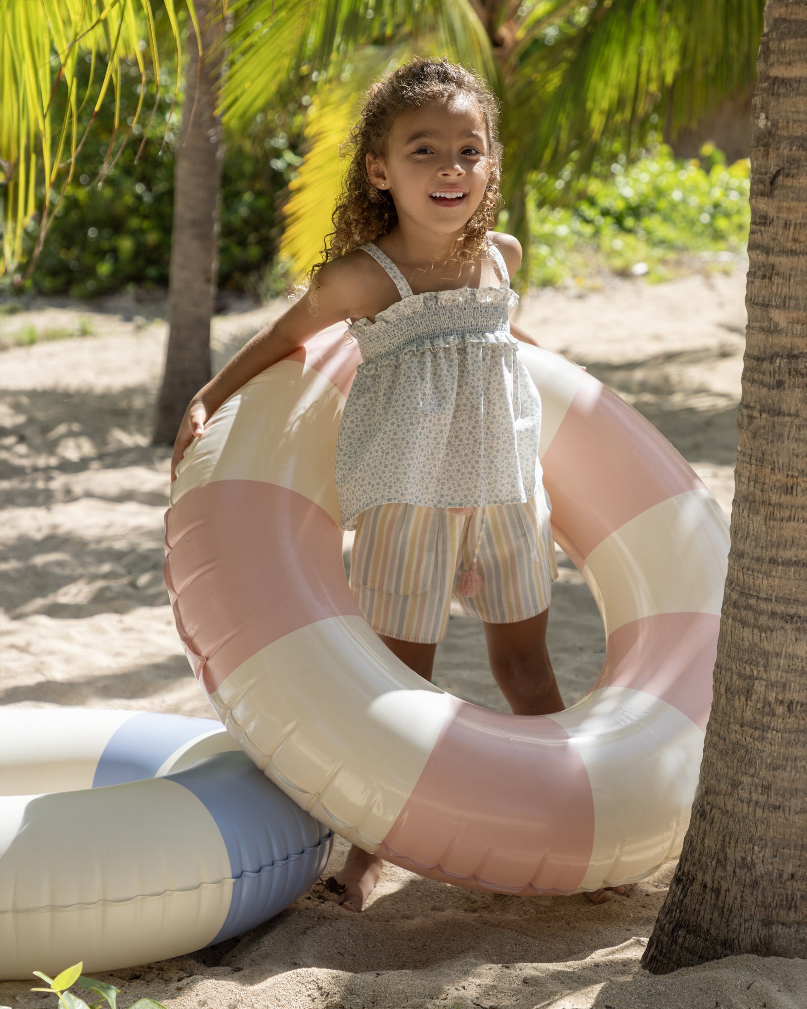 Early Sunday, Olivia Blouse in Mini Flower print, made from Printed canvas 70% Cotton 30% Linen fabric, featuring smocked bodice for a flexible fit, cross-back straps and a flared hem, shown in a front view of model wearing it
