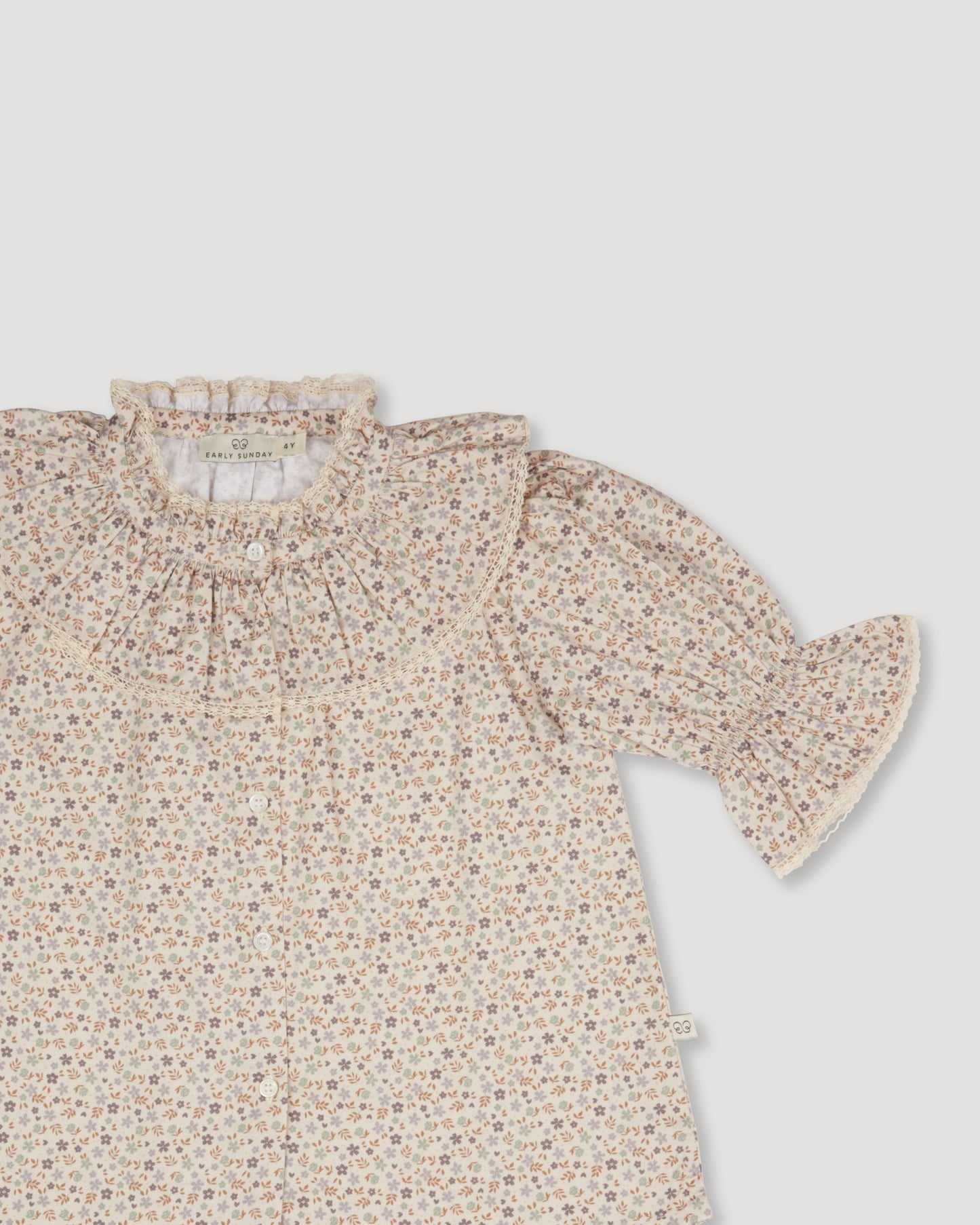 Early Sunday, Ophelie Blouse in Miny Flowers print, made from Printed Cotton Satin fabric, featuring Comfort-first design with a playful silhouette and French seams, shown in a closeup flat-lay view
