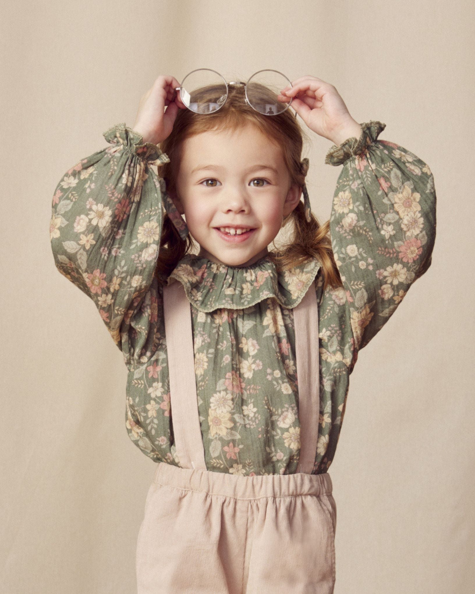 Early Sunday, Paloma Blouse in Autumn Bloom Soft Green, made from Printed Cotton Double Gauze fabric, featuring relaxed fit with a ruffle neckline, shown in a front view of model wearing it