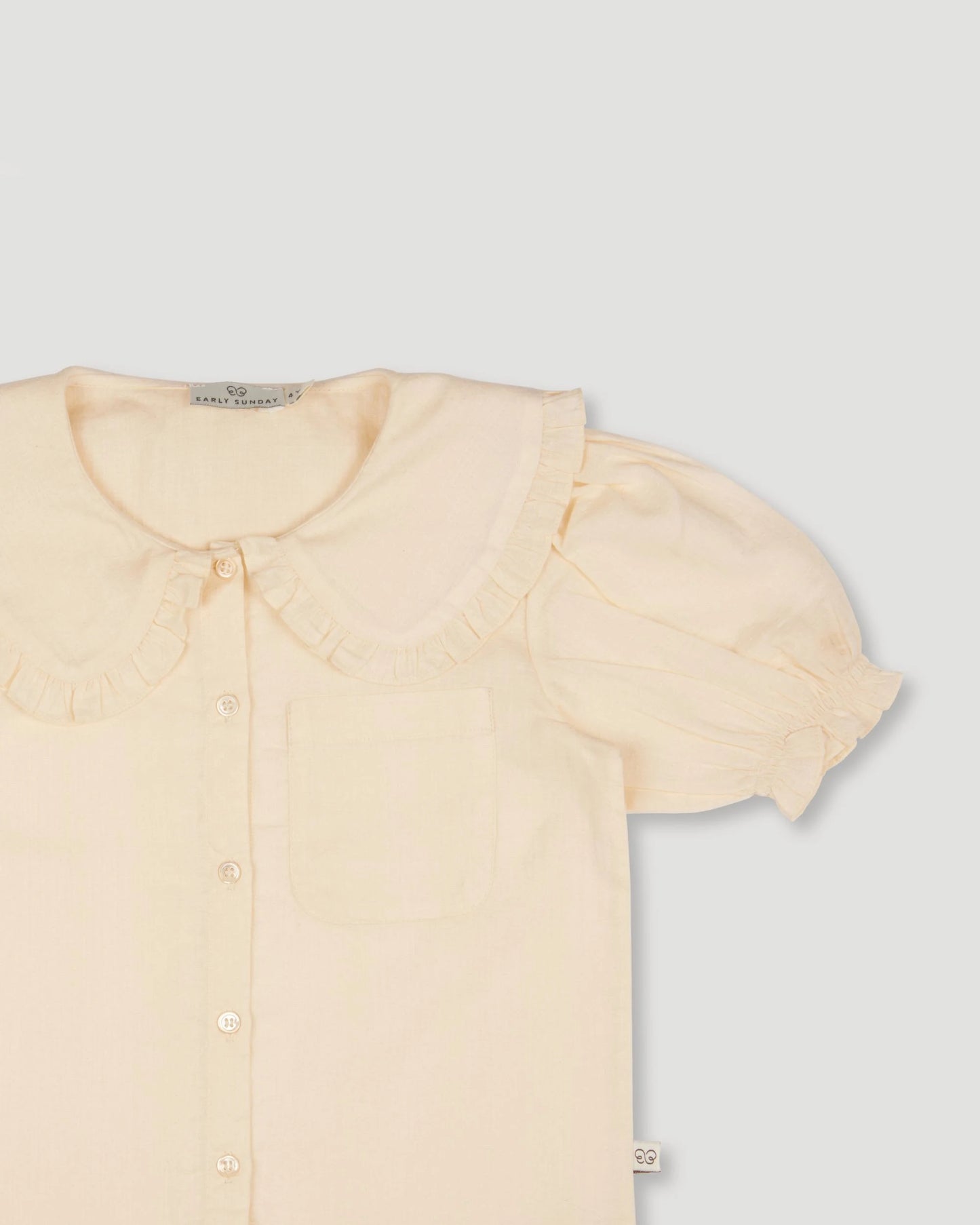 Early Sunday, Peggy Pyjama Set in Hazelnut Cream, made from Dyed Cotton Swiss Dobby Tiny Dots fabric, featuring Button-down shirt with classic tailoring, subtle gathers, and gentle volume, shown in a closeup flat-lay view