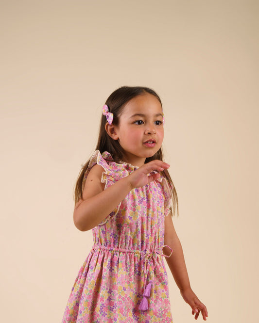 Early Sunday, Penelope Clip in Emma Floral Purple color, made from Organic Printed Cotton Cambric fabric, featuring a set of two bow clips with a secure fit, shown in side view of model wearing it