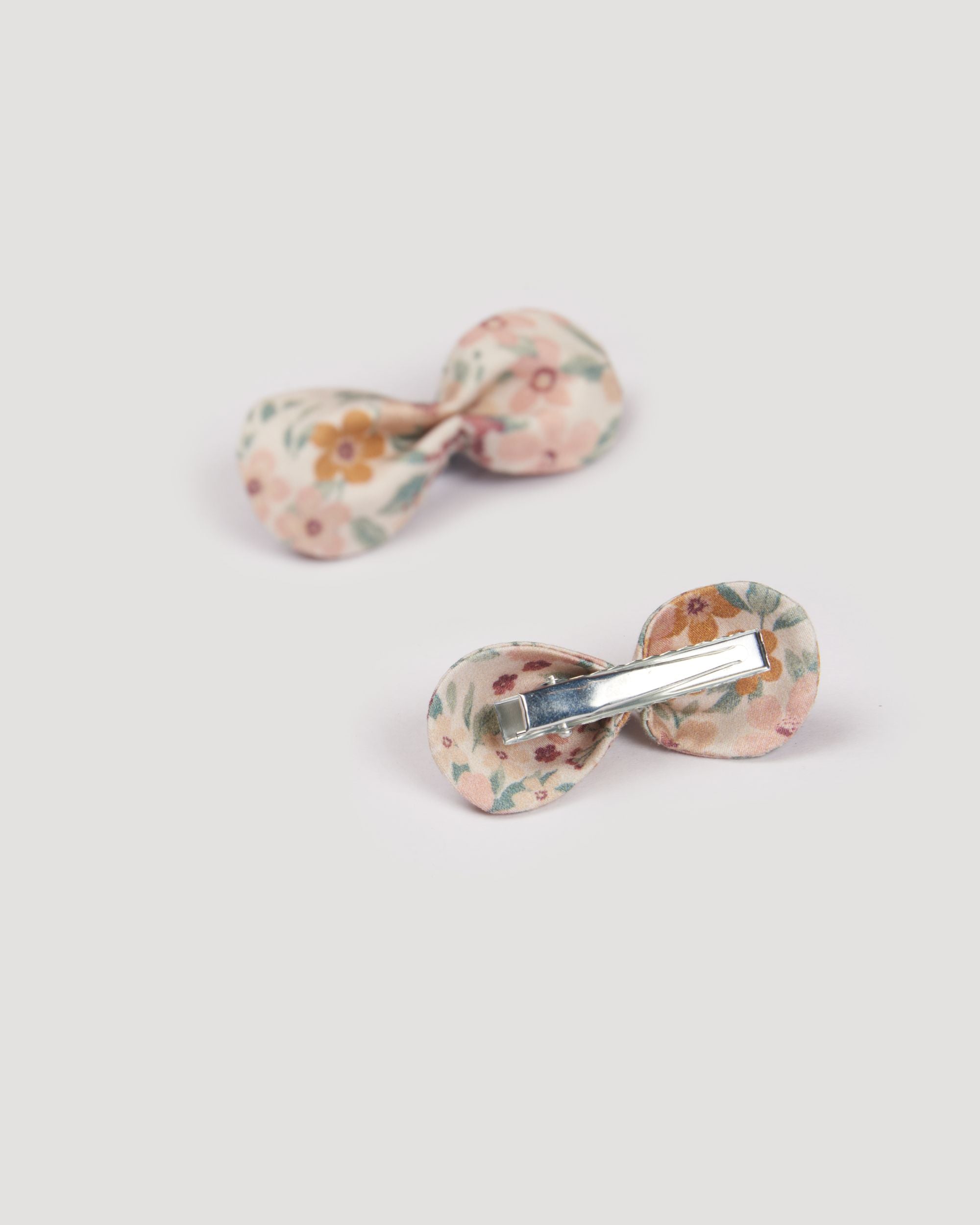 Early Sunday, Penelope Clip in Floral print, made from Printed 60s Cotton Satin fabric, featuring a set of two bow clips with a secure fit, shown in a back flat-lay view