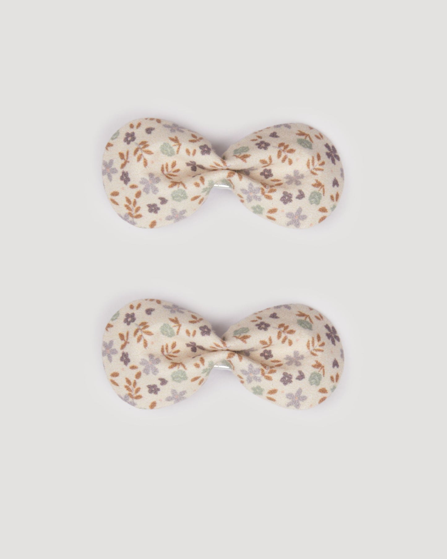 Early Sunday, Penelope Clip in Mini Flowers print, made from Printed 60s Cotton Satin fabric, featuring a set of two bow clips with a secure fit, shown in a front flat-lay view