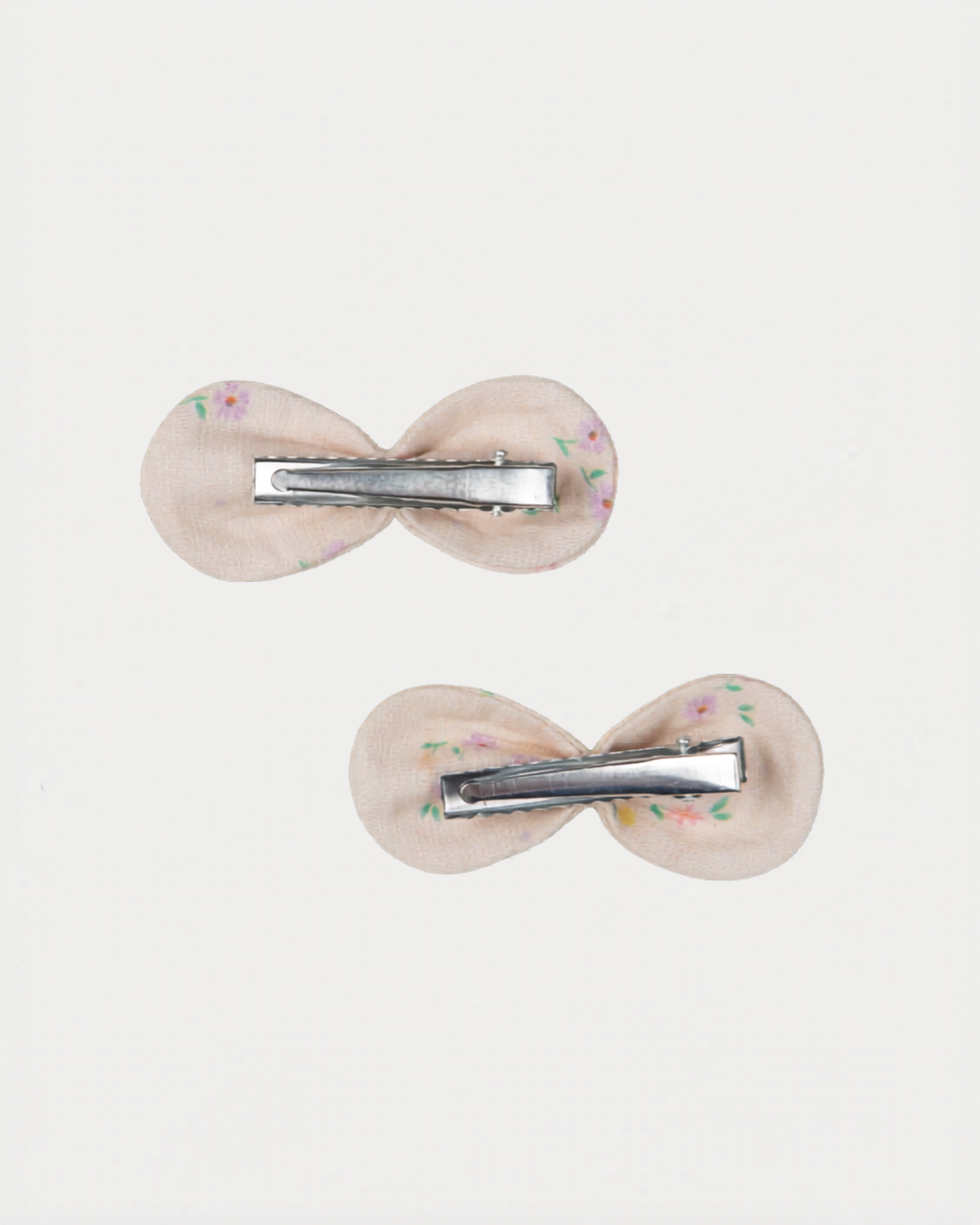 Early Sunday, Penelope Clip in Painted Bouquet print, made from Printed 70% Cotton, 30% Linen fabric, featuring a set of two bow clips with a secure fit, shown in a back flat-lay view