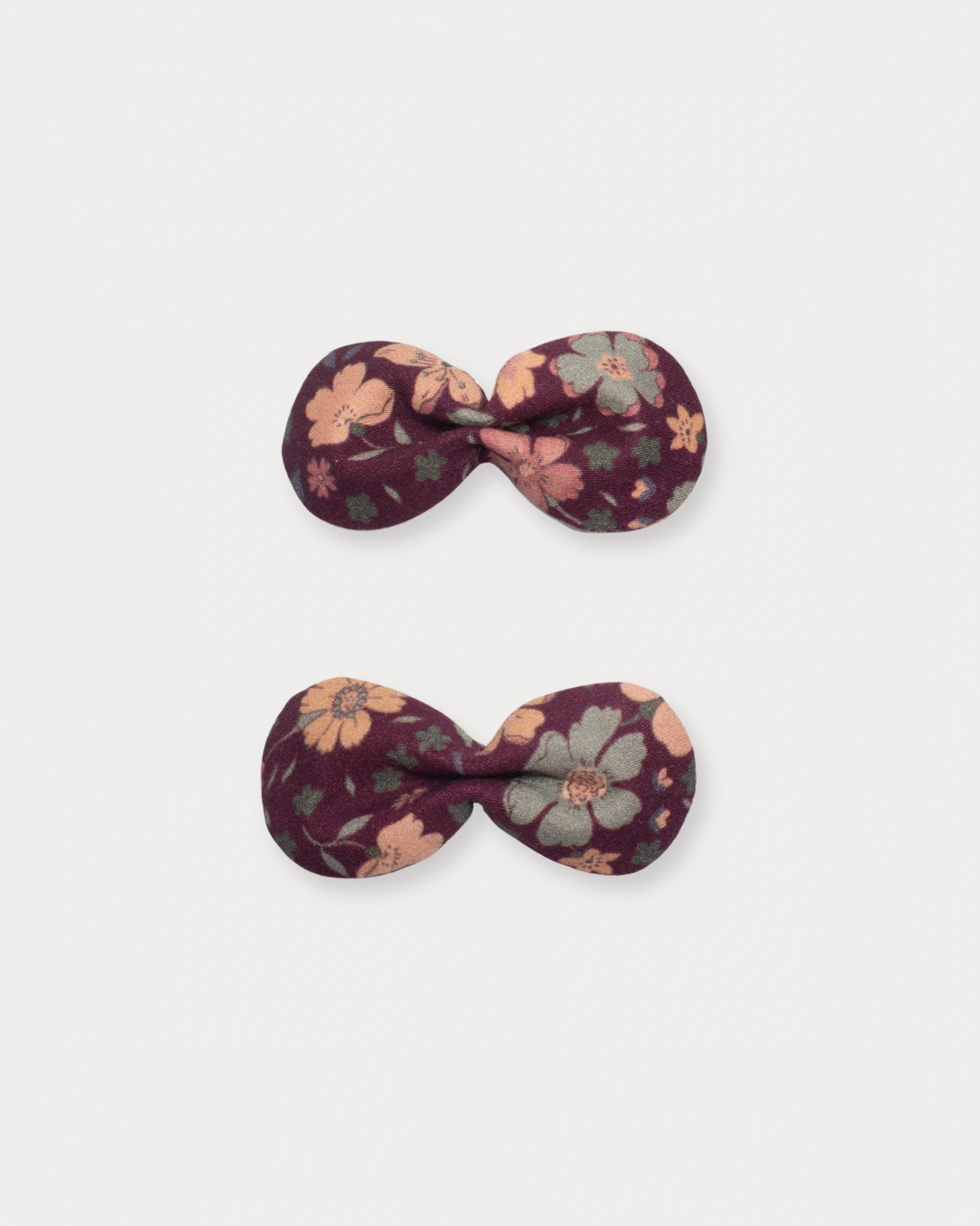 Early Sunday, Penelope Clip in Garden Flowers Plum, made from Printed Cotton Satin fabric, featuring a set of two bow clips with a secure fit, shown in a front flat-lay view