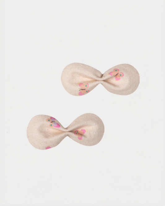 Early Sunday, Penelope Clip in Butterflies print, made from Printed Cotton Tiny Swiss Dobby fabric, featuring a set of two bow clips with a secure fit, shown in a front flat-lay view