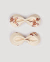 Early Sunday, Penelope Clip in Ditsy Bouquet Cream print, made from Printed Viscose Twill fabric, featuring a set of two bow clips with a secure fit, shown in a front flat-lay view