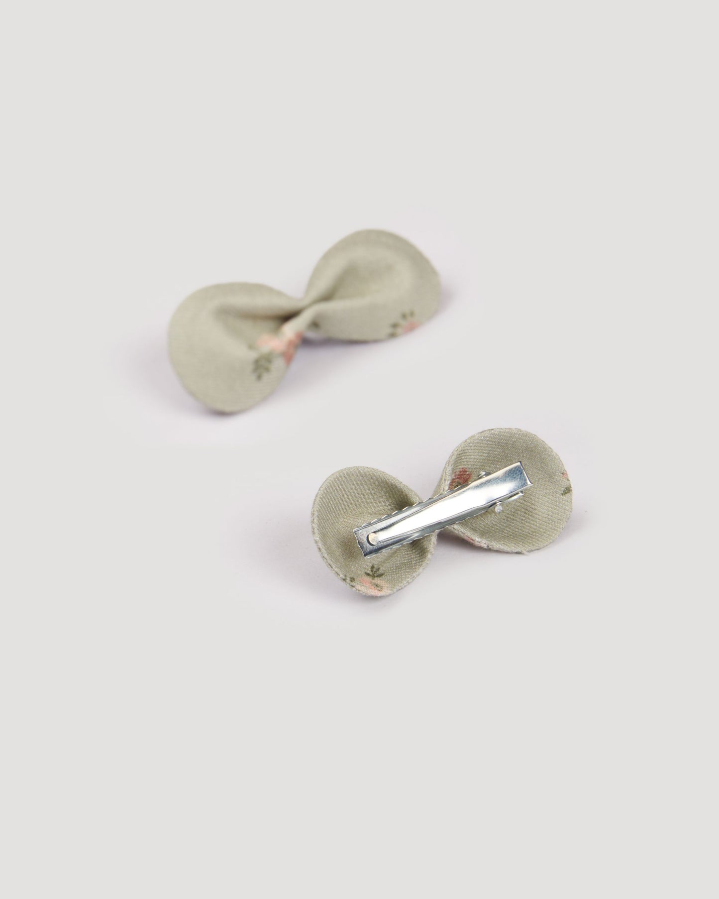 Early Sunday, Penelope Clip in Ditsy Bouquet Jade print, made from Printed Viscose Twill fabric, featuring a set of two bow clips with a secure fit, shown in a back flat-lay view