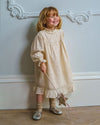 Early Sunday, Penelope Dress in Hazelnut Cream, made from All-Over Embroidered Cotton Cambric fabric, featuring Hand-embroidered floral motifs, shown in a front view of a model wearing it in a studio setting