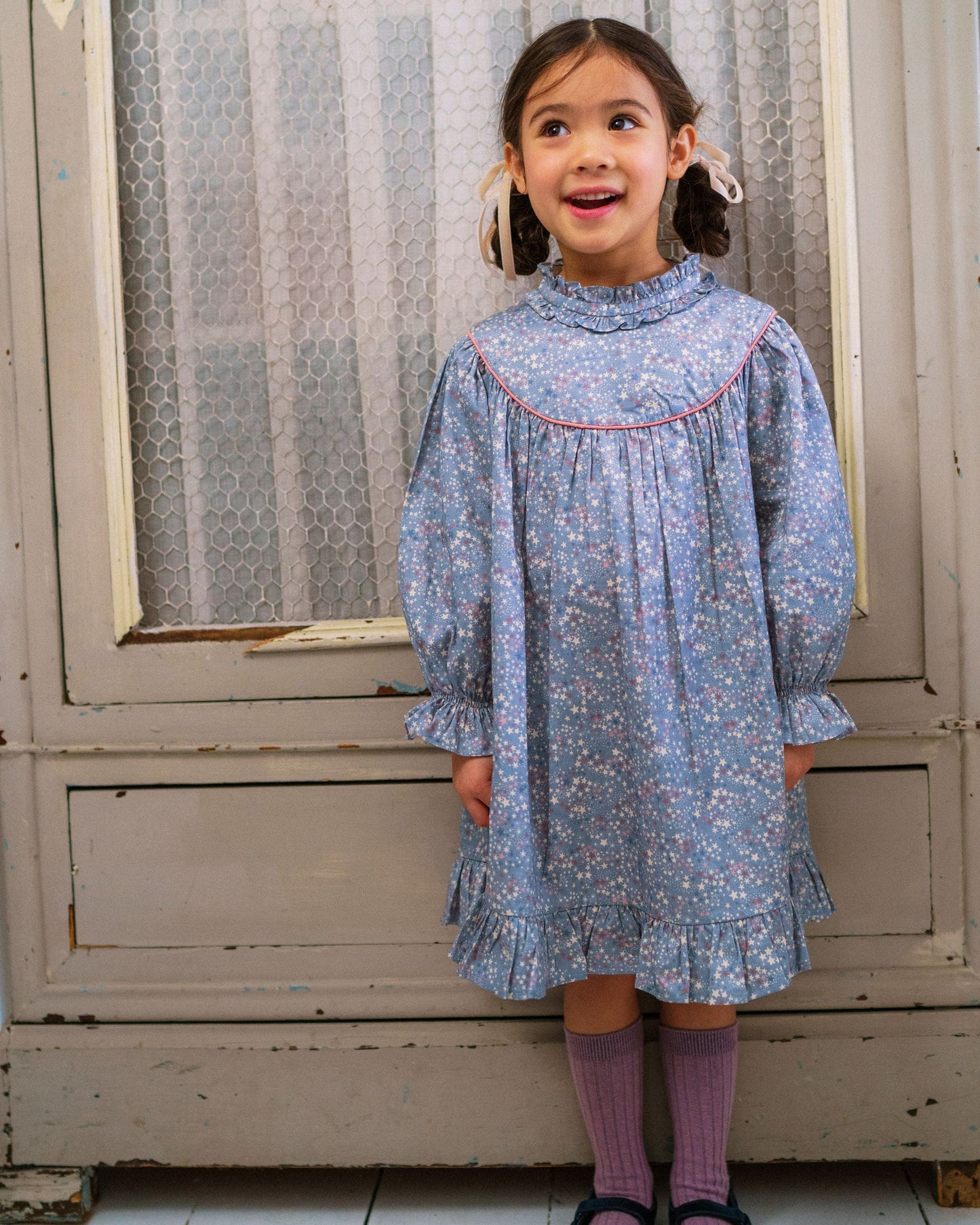 Early Sunday, Penelope Dress in Celestial print, made from Printed Cotton Satin fabric, featuring Hand-embroidered floral motifs, shown in a front view of a model wearing it in a studio setting