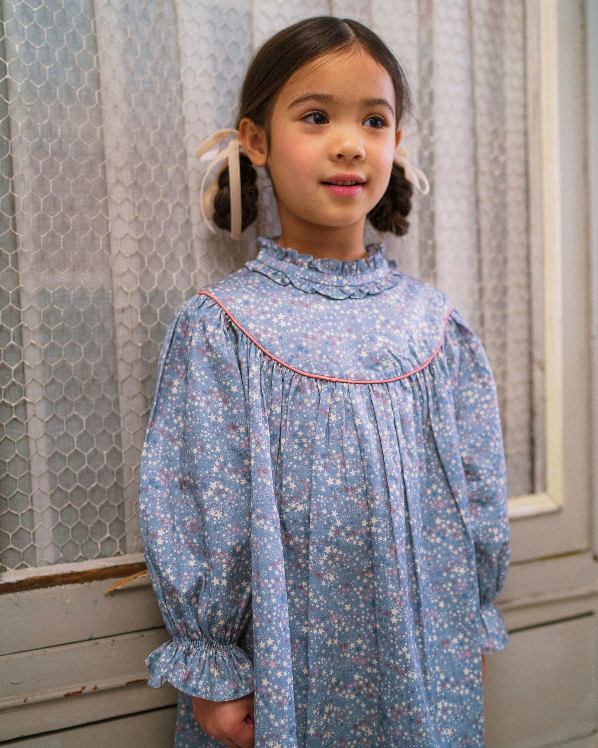 Early Sunday, Penelope Dress in Celestial print, made from Printed Cotton Satin fabric, featuring Hand-embroidered floral motifs, shown in a close up shot of model wearing it