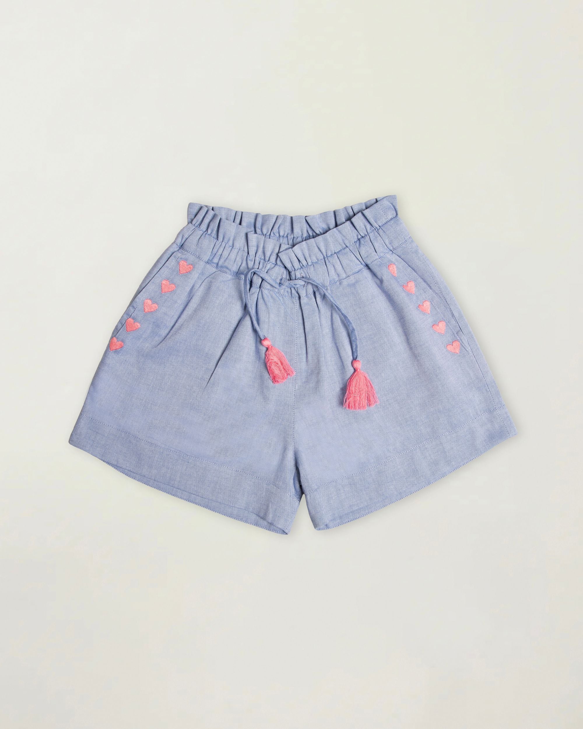 Early Sunday, Roman Short in Summer Sky color, made from 100% Cotton Chambray fabric, featuring a relaxed fit with an elastic waistband & beautiful embroidery, shown in a front flat-lay view