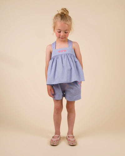 Early Sunday, Roman Short in Summer Sky color, made from 100% Cotton Chambray fabric, featuring a relaxed fit with an elastic waistband & beautiful embroidery, shown in a front view of a model wearing it in a studio setting