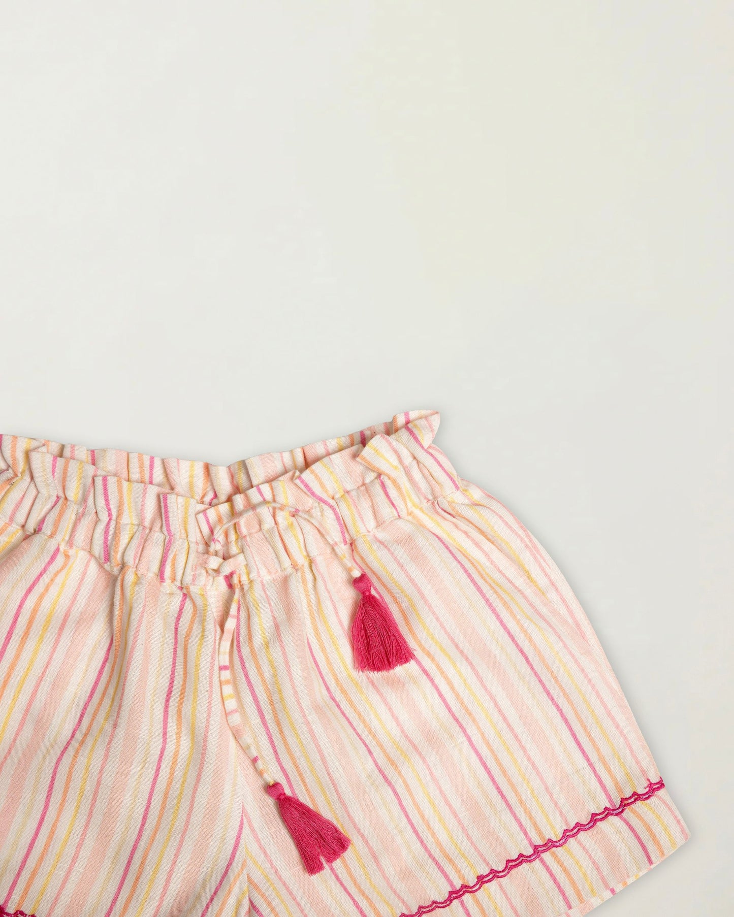Early Sunday, Roman Short in Pink Strips print, made from 70% Cotton 30% Linen fabric, featuring a relaxed fit with an elastic waistband & striped design, shown in a closeup flat-lay view