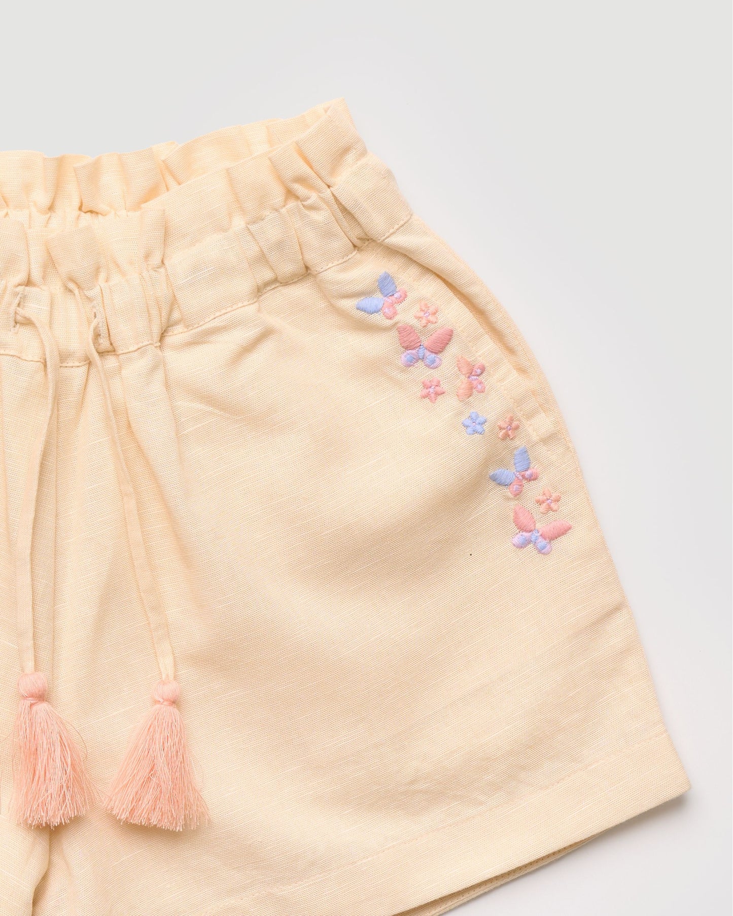 Early Sunday, Roman Short in Sand color, made from 70% Cotton 30% Linen fabric, featuring a relaxed fit with an elastic waistband & beautiful embroidery, shown in a closeup flat-lay view