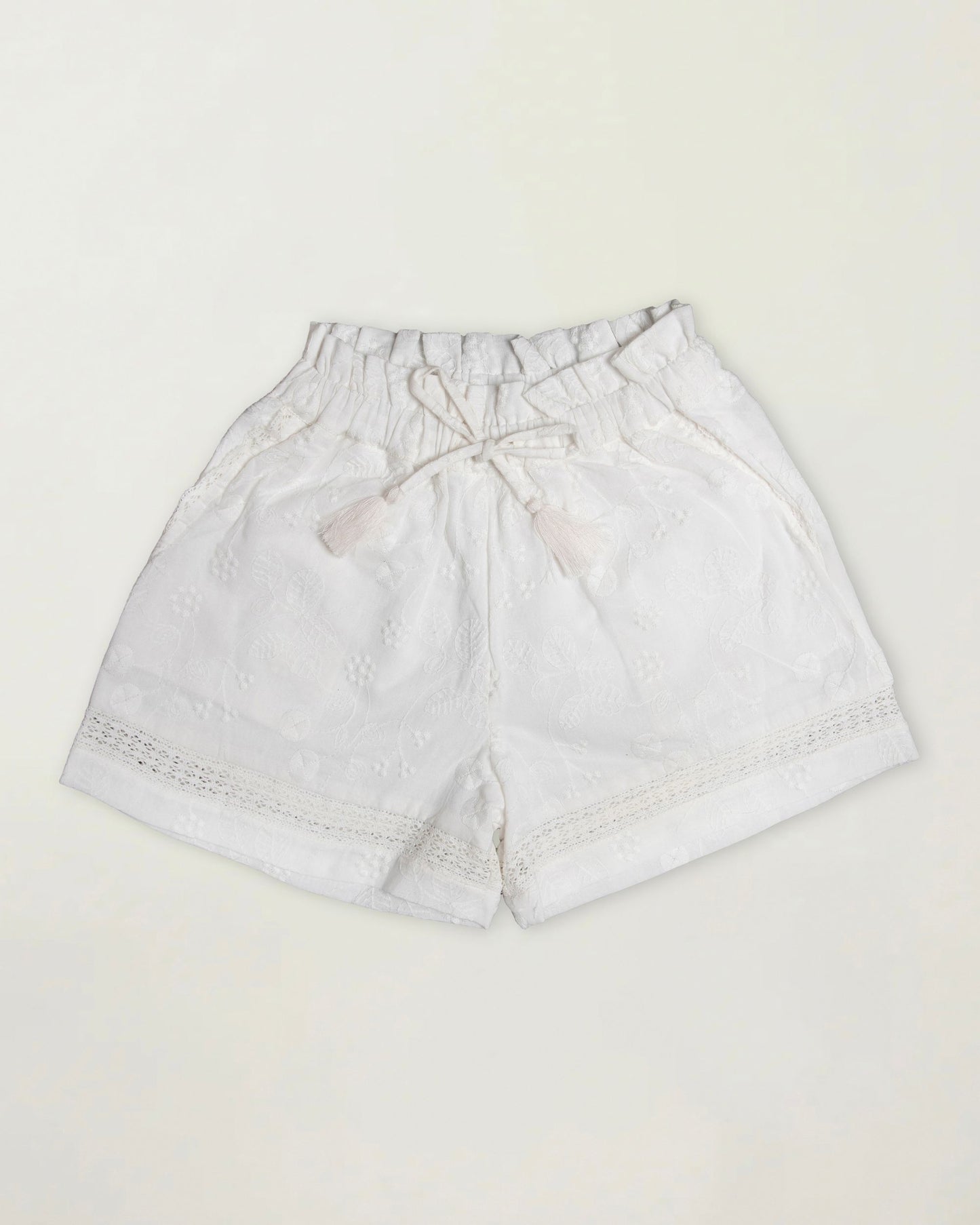 Early Sunday, Roman Short in Ivory color, made from All Over Embroidery fabric, featuring a relaxed fit with an elastic waistband & beautiful embroidery, shown in a front flat-lay view