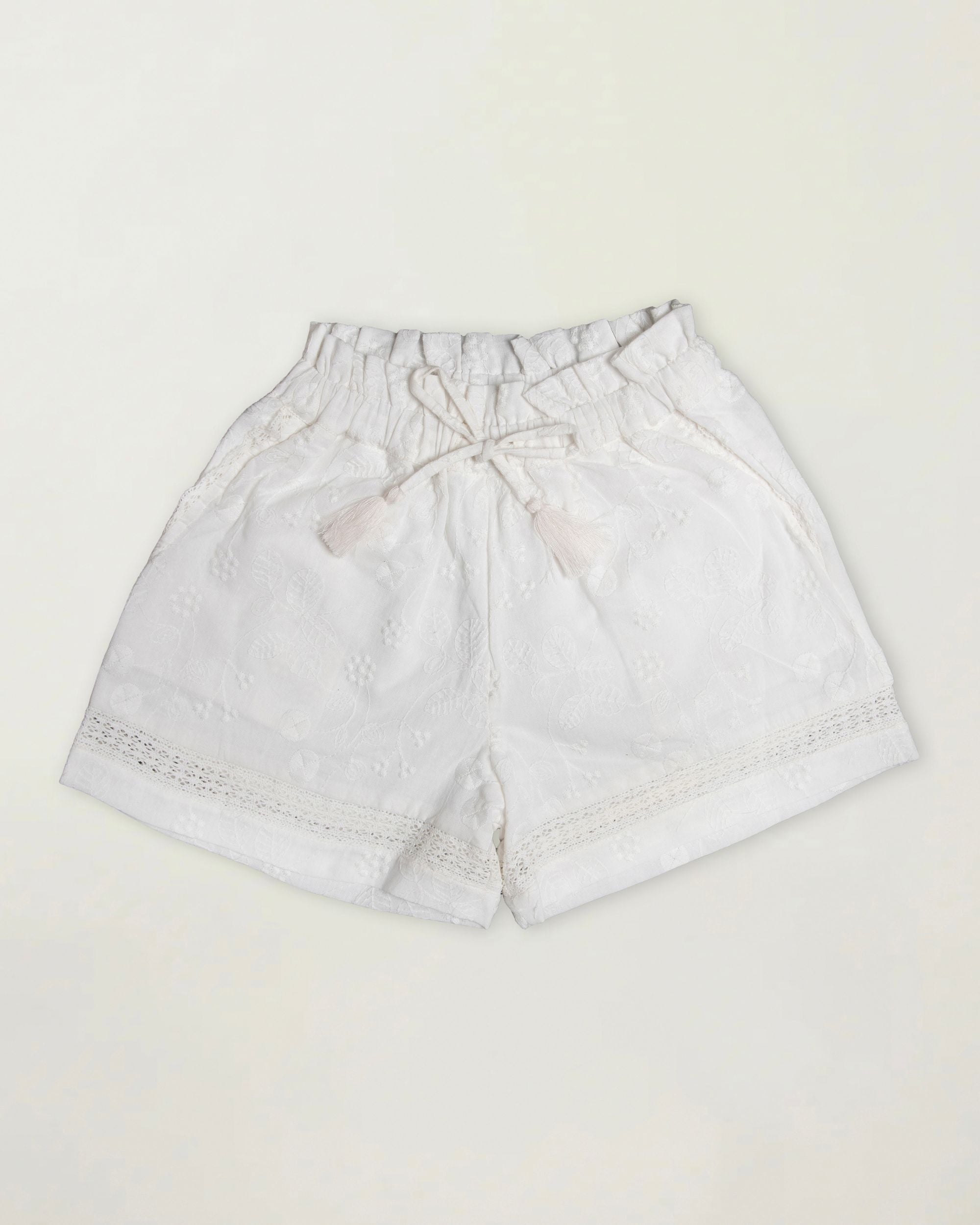 Early Sunday, Roman Short in Ivory color, made from All Over Embroidery fabric, featuring a relaxed fit with an elastic waistband & beautiful embroidery, shown in a front flat-lay view