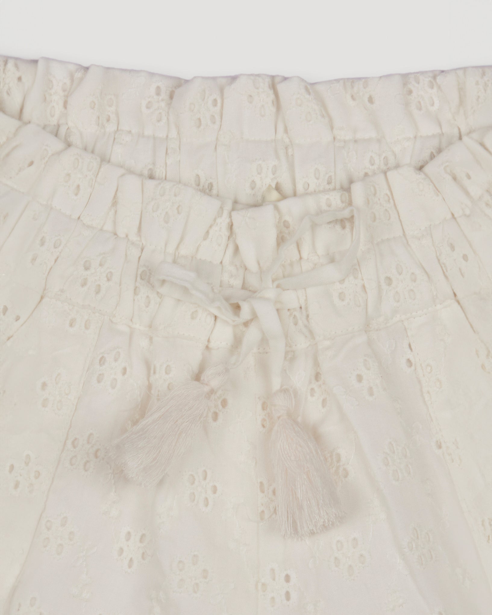 Early Sunday, Roman Shorts in Ivory color, made from All-Over Eyelet Embroidered Cotton Schifflie fabric, featuring relaxed fit with delicate finishes, combining style and functionality, shown in a closeup flat-lay view