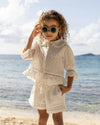 Early Sunday, Roman Shorts in Ivory color, made from All-Over Eyelet Embroidered Cotton Schifflie fabric, featuring relaxed fit with delicate finishes, combining style and functionality, shown in a front view of model wearing it