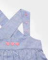 Early Sunday, Romy Blouse in Summer Sky color, made from  100% Cotton Chambray fabric, featuring a sleeveless design with cross-back straps, a gathered waist & a beautiful embroidery, shown in a closeup flat-lay view