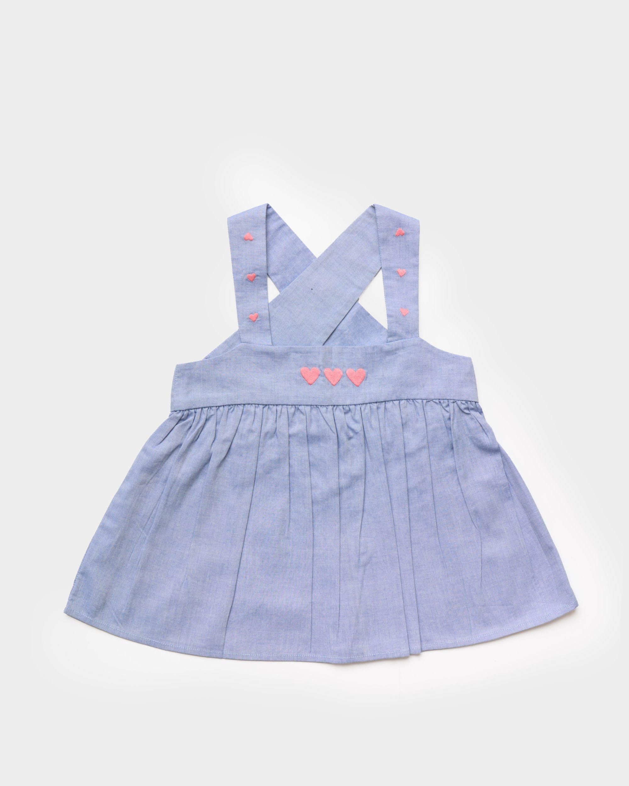 Early Sunday, Romy Blouse in Summer Sky color, made from  100% Cotton Chambray fabric, featuring a sleeveless design with cross-back straps, a gathered waist & a beautiful embroidery, shown in a front flat-lay view