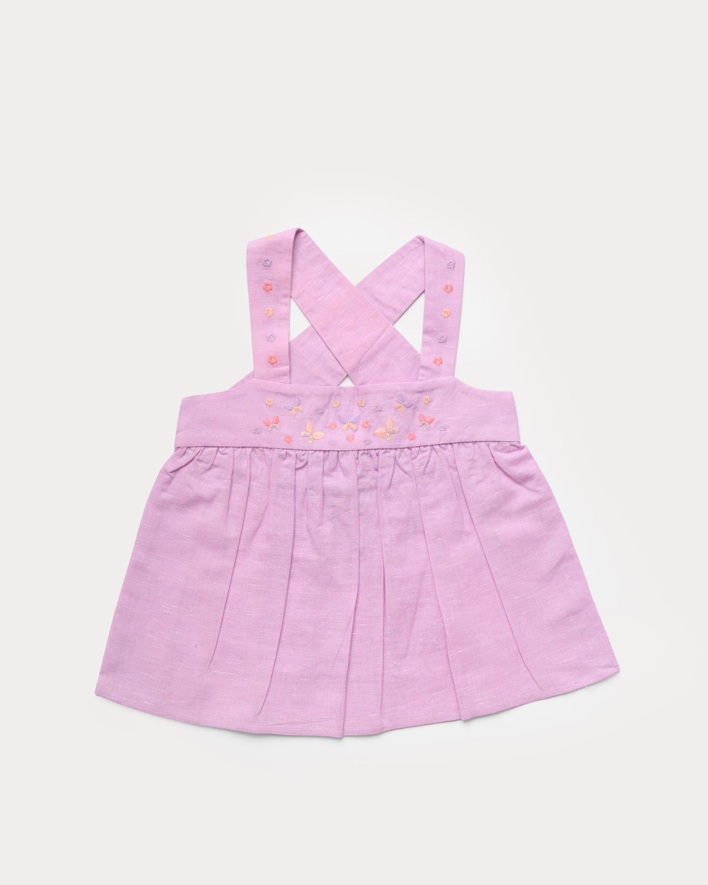 Early Sunday, Romy Blouse in Lilac color, made from 70% Cotton 30% Linen fabric, featuring a sleeveless design with cross-back straps, a gathered waist & a beautiful embroidery, shown in a front flat-lay view