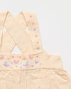 Early Sunday, Romy Blouse in Sand color, made from 70% Cotton 30% Linen fabric, featuring a sleeveless design with cross-back straps, a gathered waist & a beautiful embroidery, shown in a closeup flat-lay view