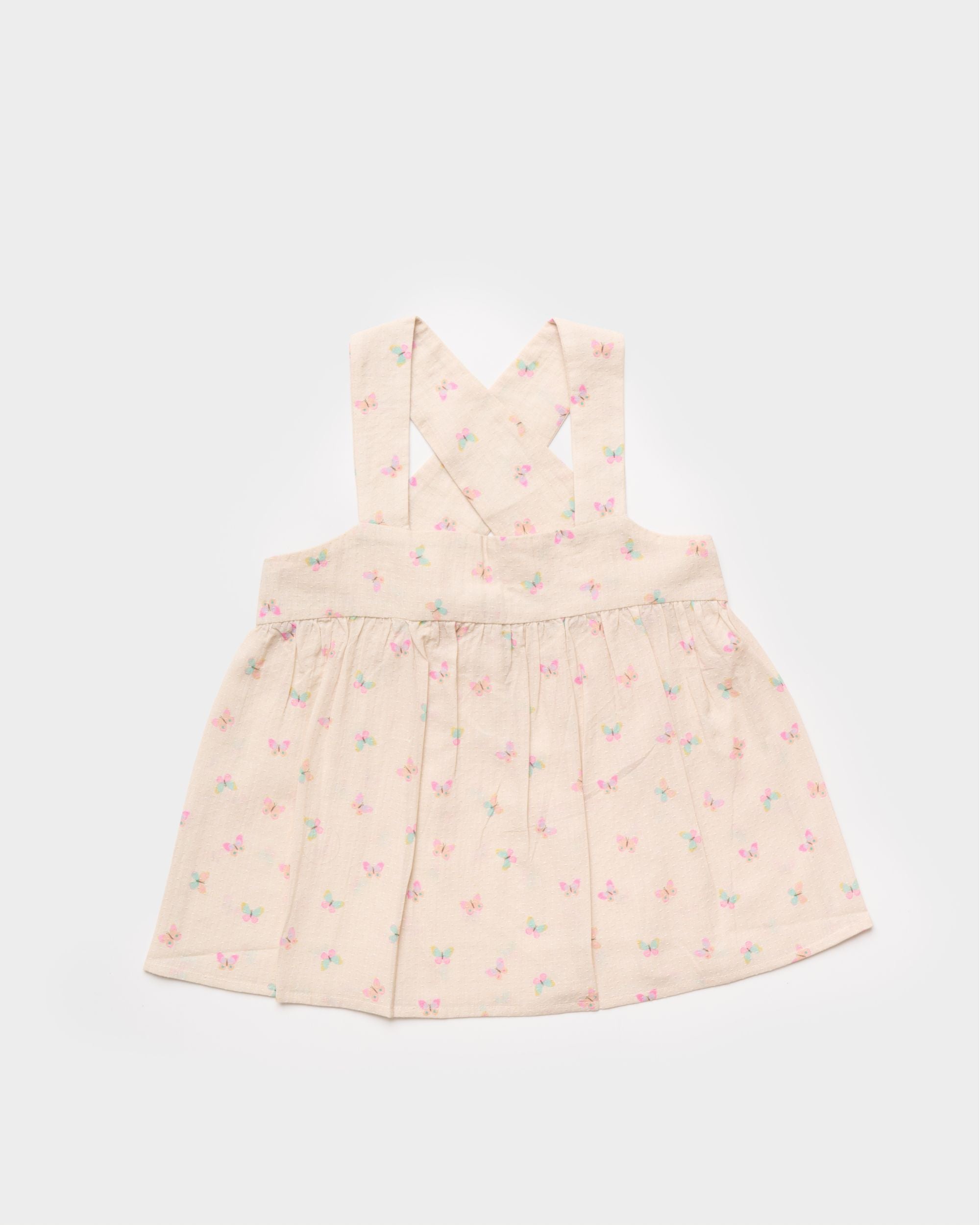 Early Sunday, Romy Blouse in Butterflies print, made from Printed Cotton Tiny Swiss Dobby fabric, featuring a sleeveless design with cross-back straps, a gathered waist & a soft flared silhouette, shown in front flat-lay view