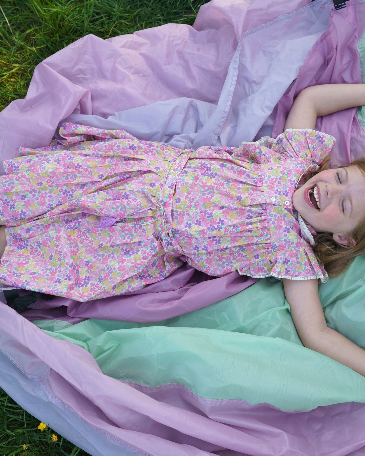 Early Sunday, Ruth Skirt in Emma Floral Purple color, made from Organic Printed Cotton Cambric fabric, featuring a flared silhouette with an elastic waistband & floral design, shown in a close up shot of model playing outdoors