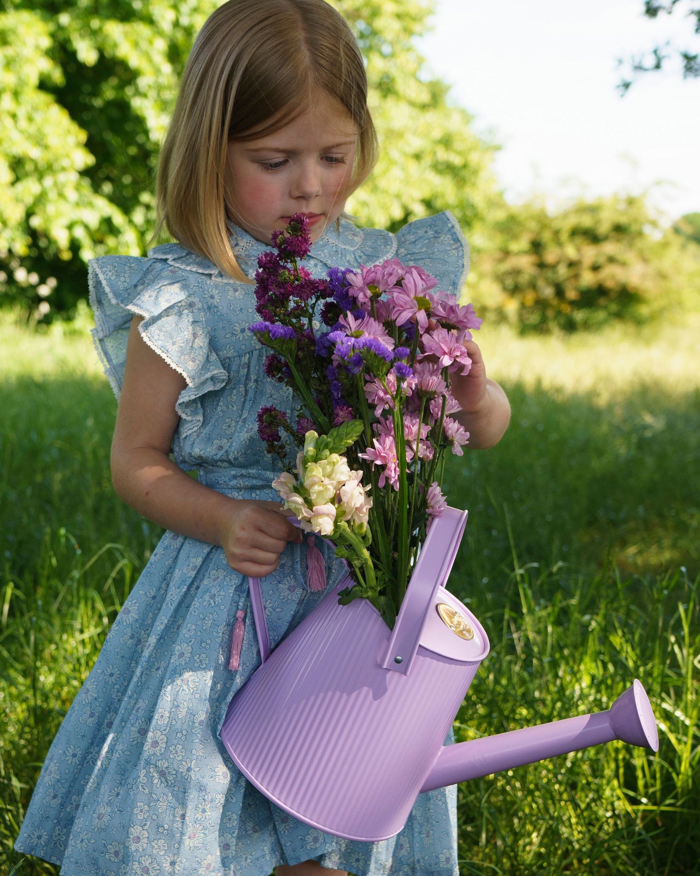 Early Sunday, Ruth Skirt in Tonal Floral Blue color, made from Printed Cotton Tiny Swiss Dobby fabric, featuring a flared silhouette with an elastic waistband & floral design, shown in a close up shot of model playing outdoors