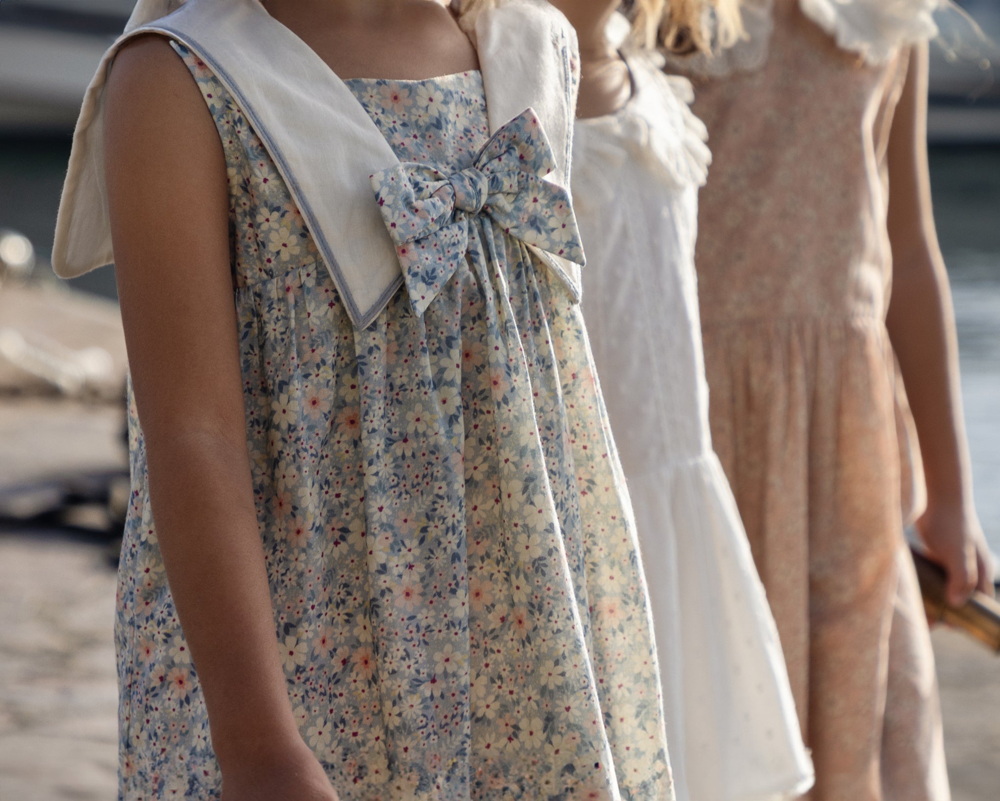 Early Sunday, Sabrina Dress in Amelia print, made from Printed Cotton Cambric fabric, featuring flattering fit with delicate finishes, combining style and functionality for an effortlessly elegant look, shown in a an angled view of a model wearing outdoors