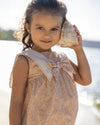 Early Sunday, Sabrina Dress in Garden Flowers print, made from Printed Cotton Cambric fabric, featuring flattering fit with delicate finishes, combining style and functionality for an effortlessly elegant look, shown in a an angled view of a model wearing outdoors