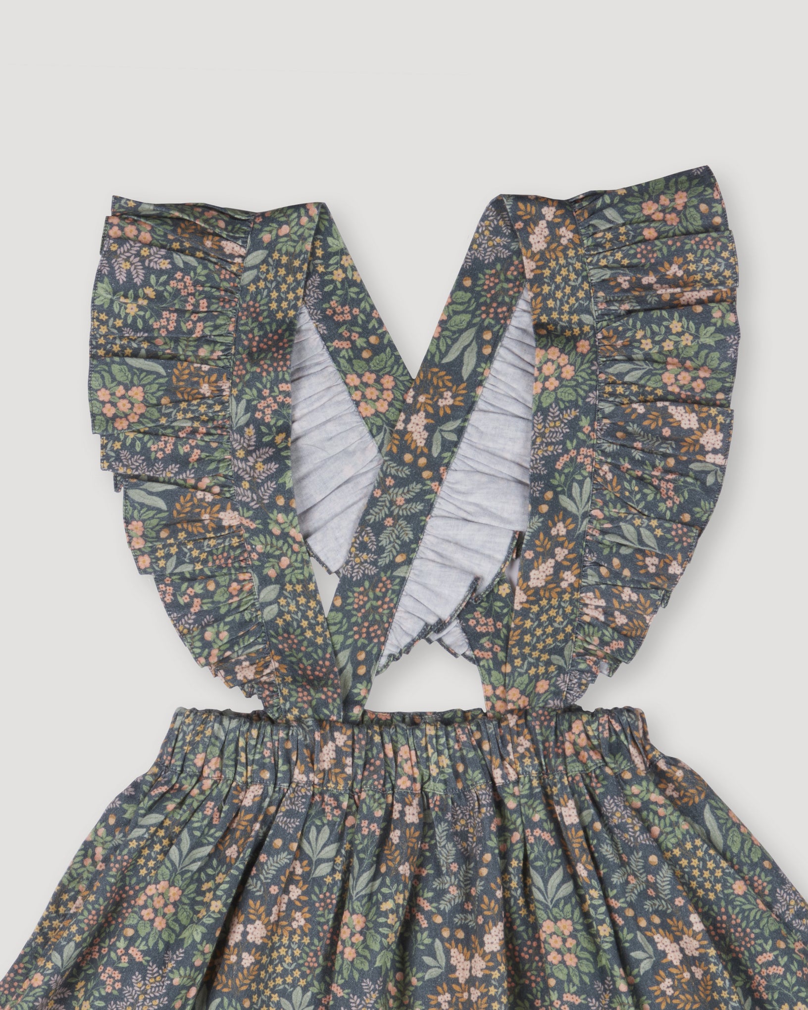 Early Sunday, Selma Skirt in Autumn Garden Greyish Blue, made from Printed Cotton Satin fabric, featuring dungaree style with adjustable straps, shown in a closeup flat-lay view