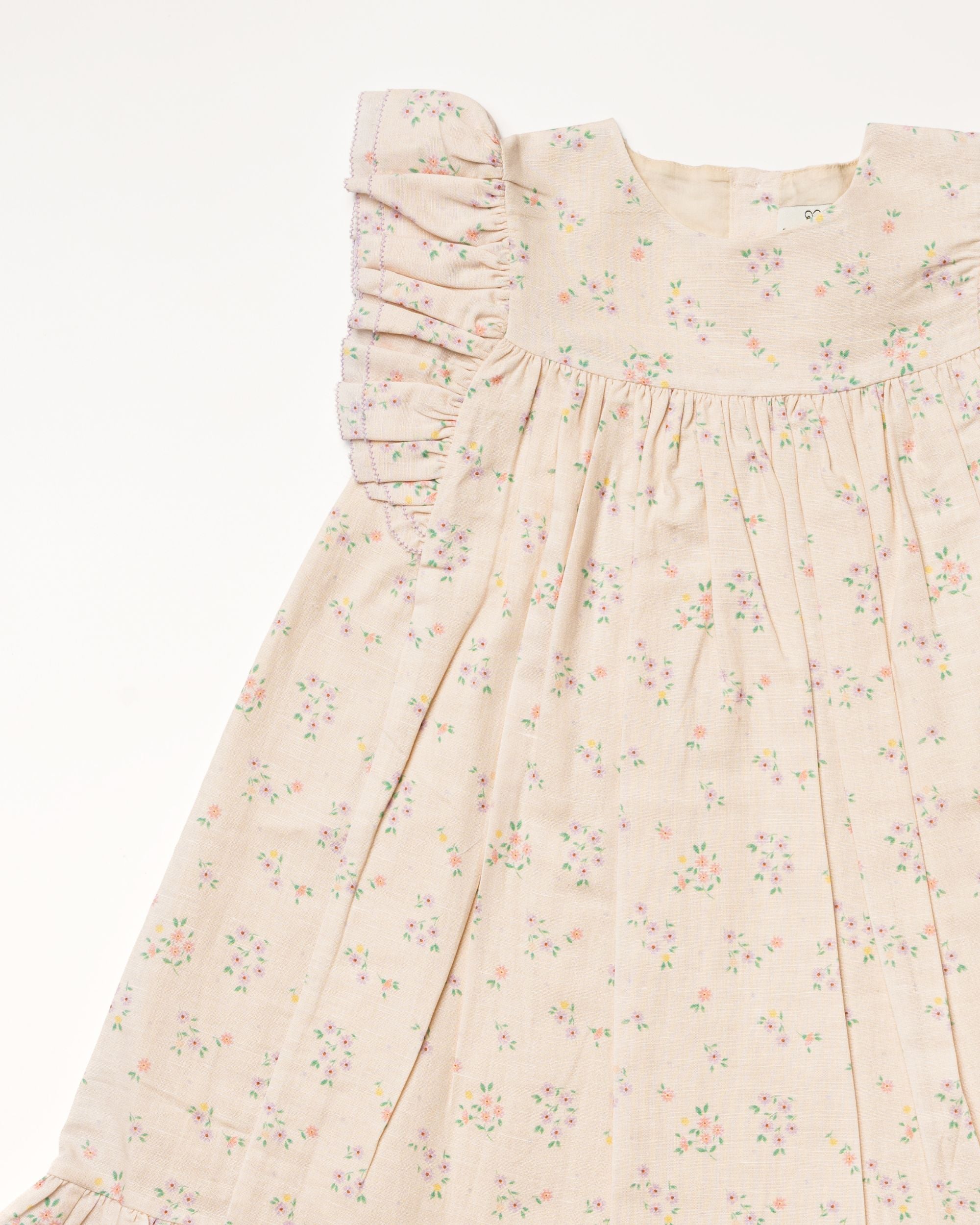 Early Sunday, Sita Dress in Painted Bouquet print, made from 70% Cotton 30% Linen fabric, featuring a sleeveless design with wide shoulder straps & a delicate lace yoke, shown in a closeup flat-lay view