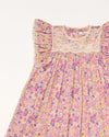 Early Sunday, Sita Dress in Emma Floral Purple color, made from Organic Printed Cotton Cambric fabric, featuring a sleeveless design with wide shoulder straps & a delicate lace yoke, shown in a closeup flat-lay view