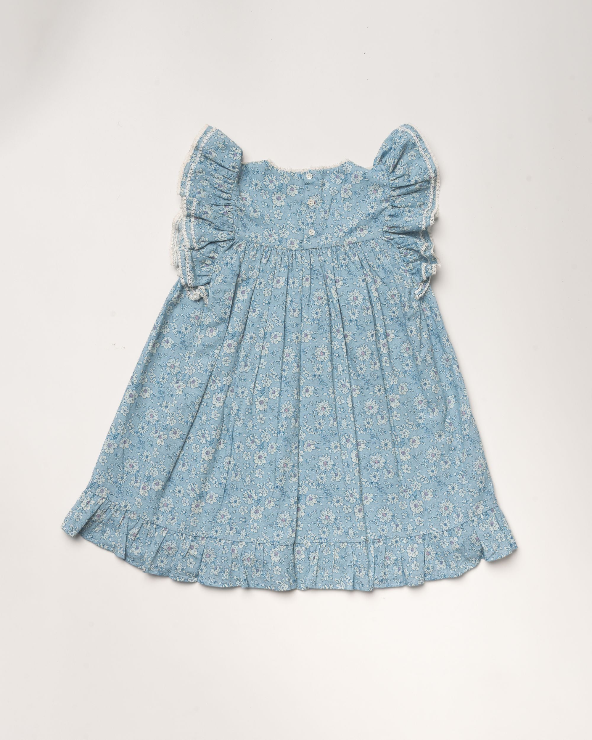 Early Sunday, Sita Dress in Tonal Floral Blue color, made from Printed Cotton Tiny Swiss Dobby fabric, featuring a sleeveless design with wide shoulder straps & a delicate lace yoke, shown in a back flat-lay view
