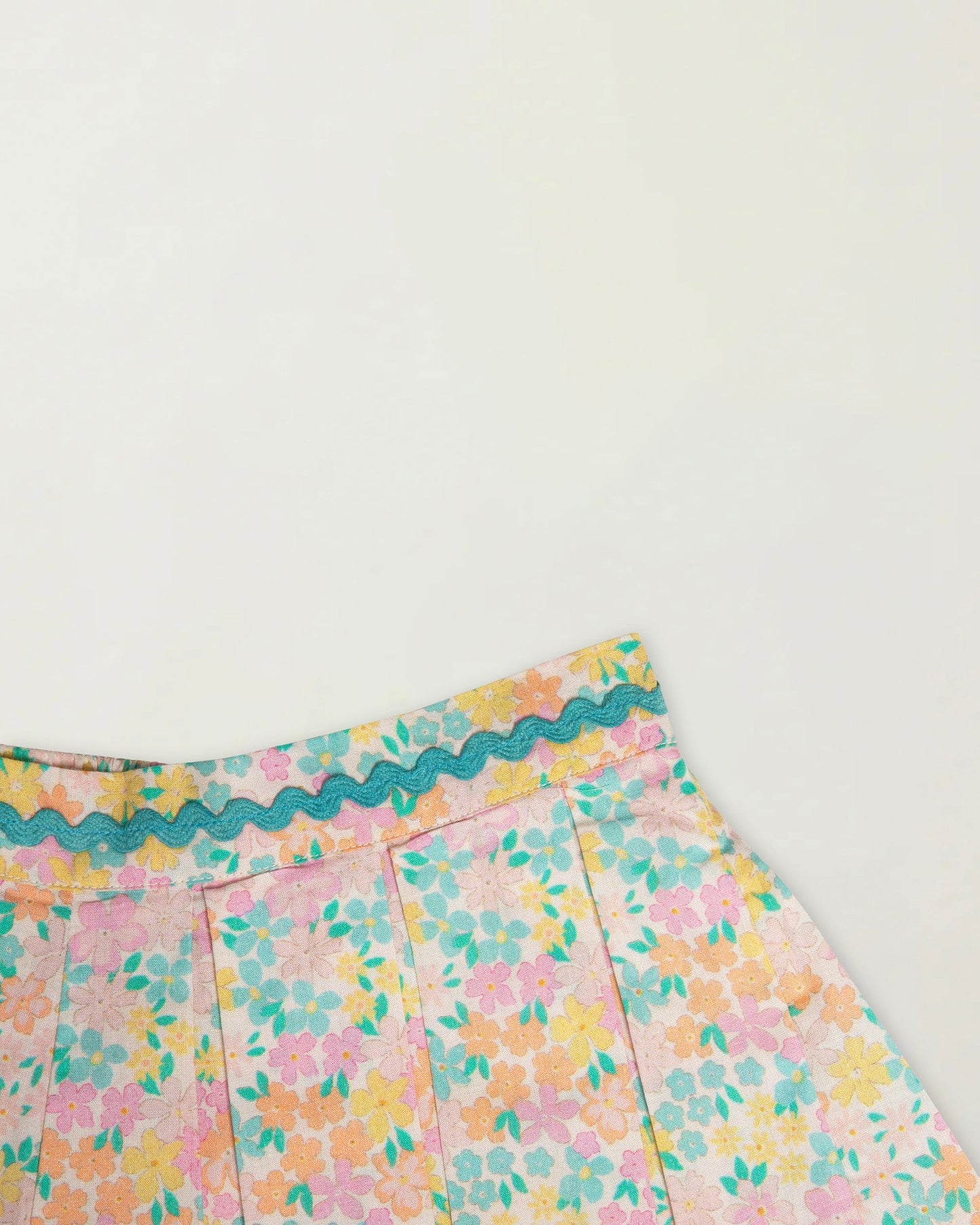 Early Sunday, Solal Skort in Emma Floral Mint color, made from Organic Printed Cotton Cambric fabric, featuring a flared skirt overlay with attached shorts & elastic waistband, shown in a closeup flat-lay view