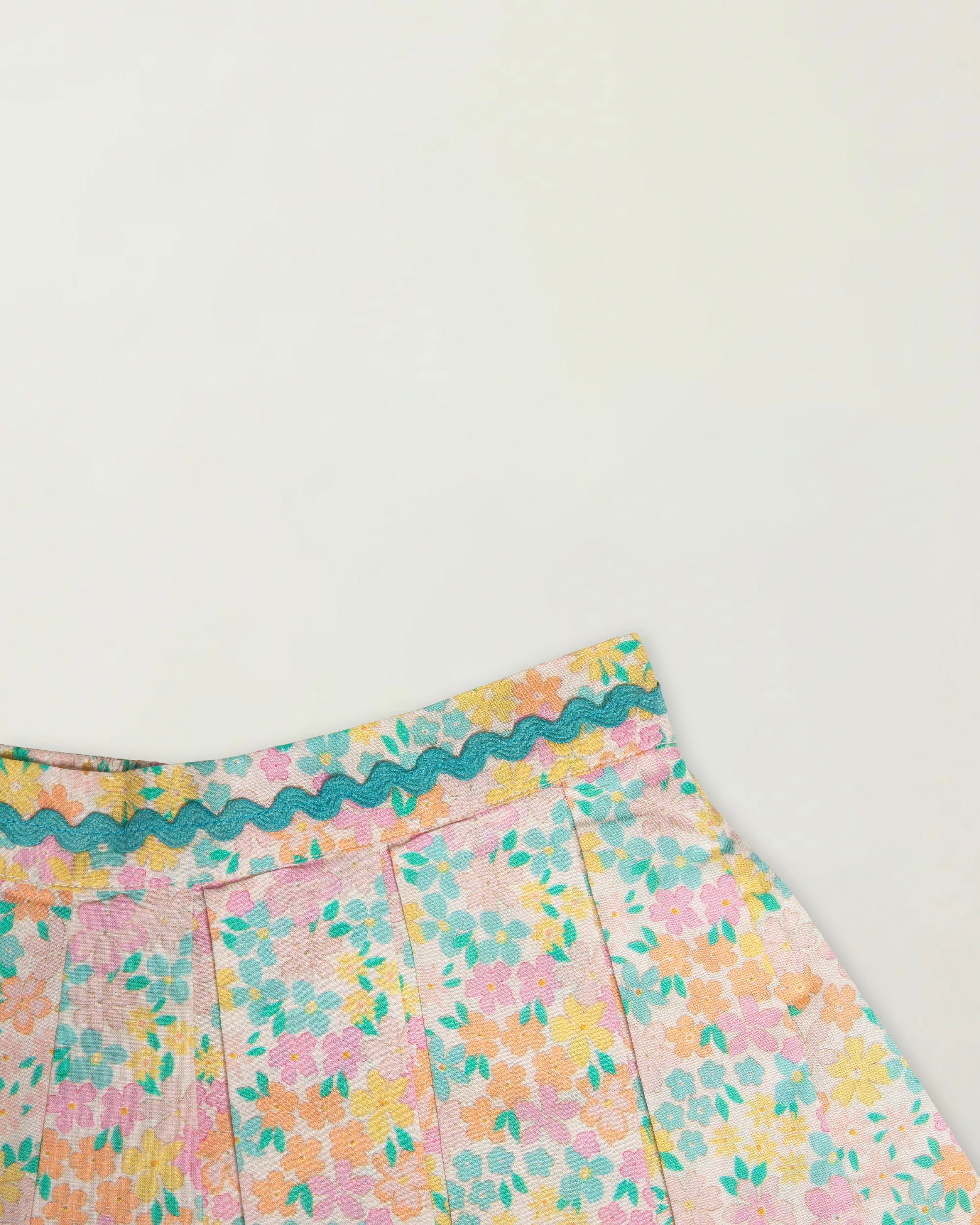 Early Sunday, Solal Skort in Emma Floral Mint color, made from Organic Printed Cotton Cambric fabric, featuring a flared skirt overlay with attached shorts & elastic waistband, shown in a closeup flat-lay view