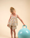 Early Sunday, Solal Skort in Emma Floral Mint color, made from Organic Printed Cotton Cambric fabric, featuring a flared skirt overlay with attached shorts & elastic waistband, shown in an angled view of a model wearing it in a studio setting