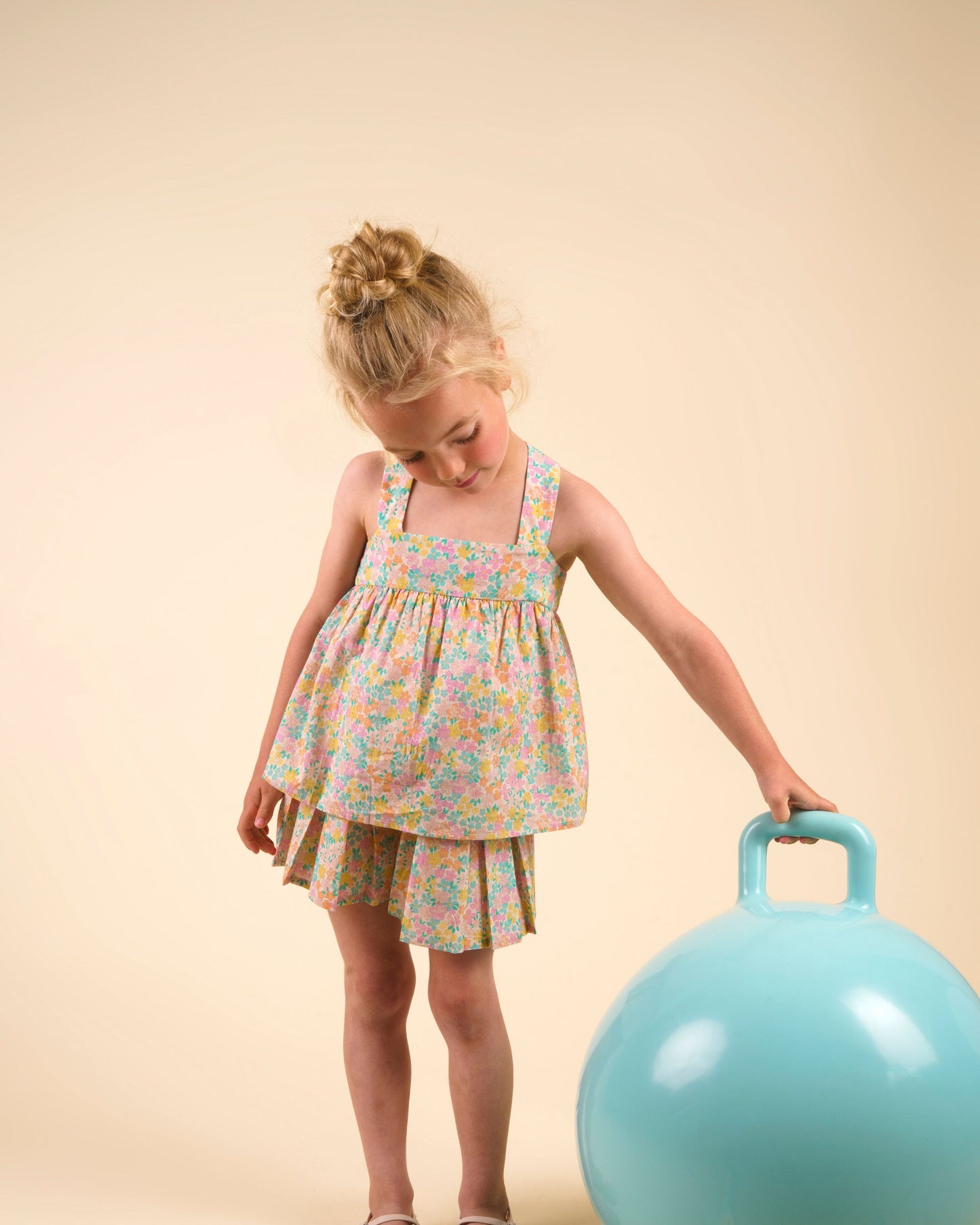 Early Sunday, Solal Skort in Emma Floral Mint color, made from Organic Printed Cotton Cambric fabric, featuring a flared skirt overlay with attached shorts & elastic waistband, shown in an angled view of a model wearing it in a studio setting